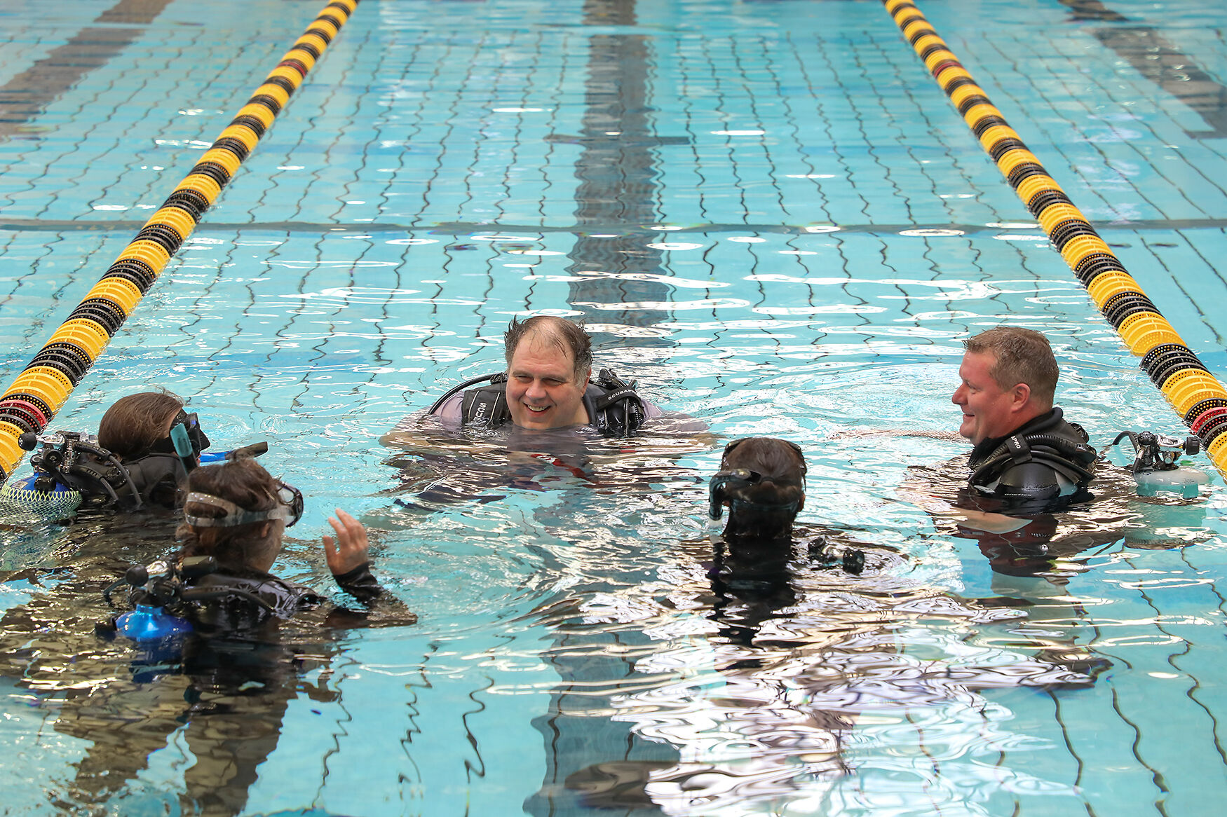 Diventures Capt. Nemo’s assistant dive instructor David Martin, center, explains diving techniques with a group of students during a scuba diving class